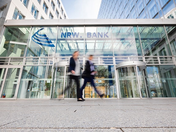 Zwei Mitarbeitende laufen am Gebäude der NRW.BANK vorbei.