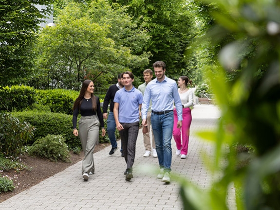 Eine Gruppe Dualstudierende läuft durch einen Park.