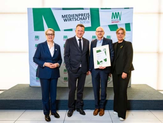Martin Mehringer gewinnt Platz 2 des MEDIENPREIS WIRTSCHAFT NRW 2025 und 3.500 Euro mit ihrem Beitrag „Das Drama“. Er erhält die Auszeichnung von Gabriela Pantring, designierte Vorsitzende des Vorstands der NRW.BANK, Wirtschafts- und Klimaschutzministerin Mona Neubaur und Edzard Bennmann von Signal Iduna (2. V. l.) (Bild: NRW.BANK / Oliver Wachenfeld)