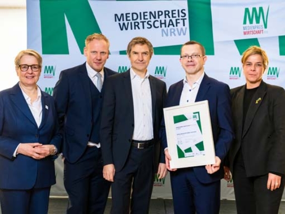 Sönke Iwersen und Volker Votsmeier gewinnen Platz 3 des MEDIENPREIS WIRTSCHAFT NRW 2025 und 1.500 Euro mit ihrem Beitrag „Die Demontage“. Sie erhalten die Auszeichnung von Gabriela Pantring, designierte Vorsitzende des Vorstands der NRW.BANK, Wirtschafts- und Klimaschutzministerin Mona Neubaur und Philipp Frahmke von den Wirtschaftsjunioren (2. V. l.) (Bild: NRW.BANK / Oliver Wachenfeld