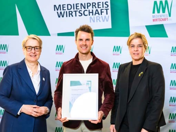 Maximilian Nowroth gewinnt den MEDIENPREIS WIRTSCHAFT NRW 2025 – regional & lokal und 3.000 Euro mit seinem Beitrag „Skandaljahr der Volksbank Düsseldorf Neuss“. Er erhält die Auszeichnung von Gabriela Pantring, designierte Vorsitzende des Vorstands der NRW.BANK, und Wirtschafts- und Klimaschutzministerin Mona Neubaur (Bild: NRW.BANK / Oliver Wachenfeld)