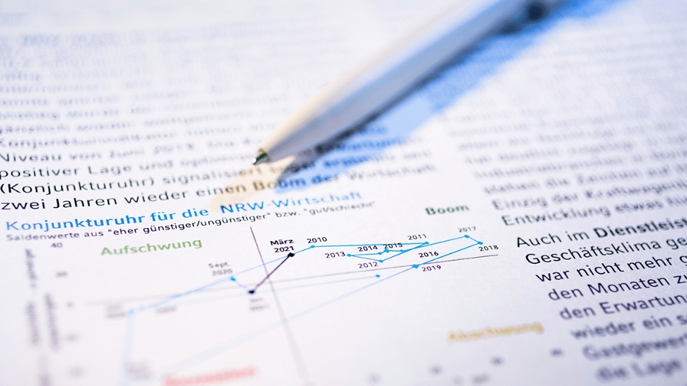 Ein Kugelschreiber liegt auf einem ausgedruckten Geschäftklima-Bericht