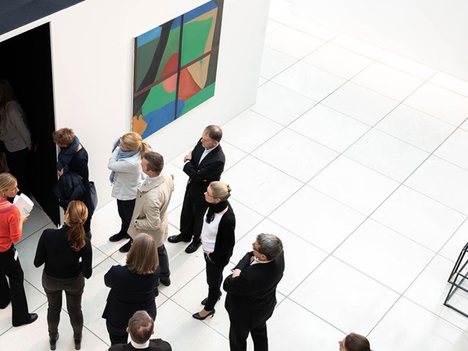 Eine Gruppe von Menschen bei einer Führung durch eine Kunstausstellung