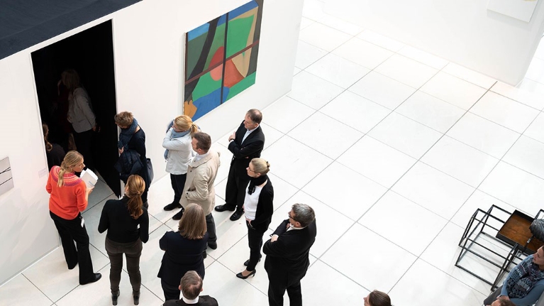 Eine Gruppe von Menschen bei einer Führung durch eine Kunstausstellung