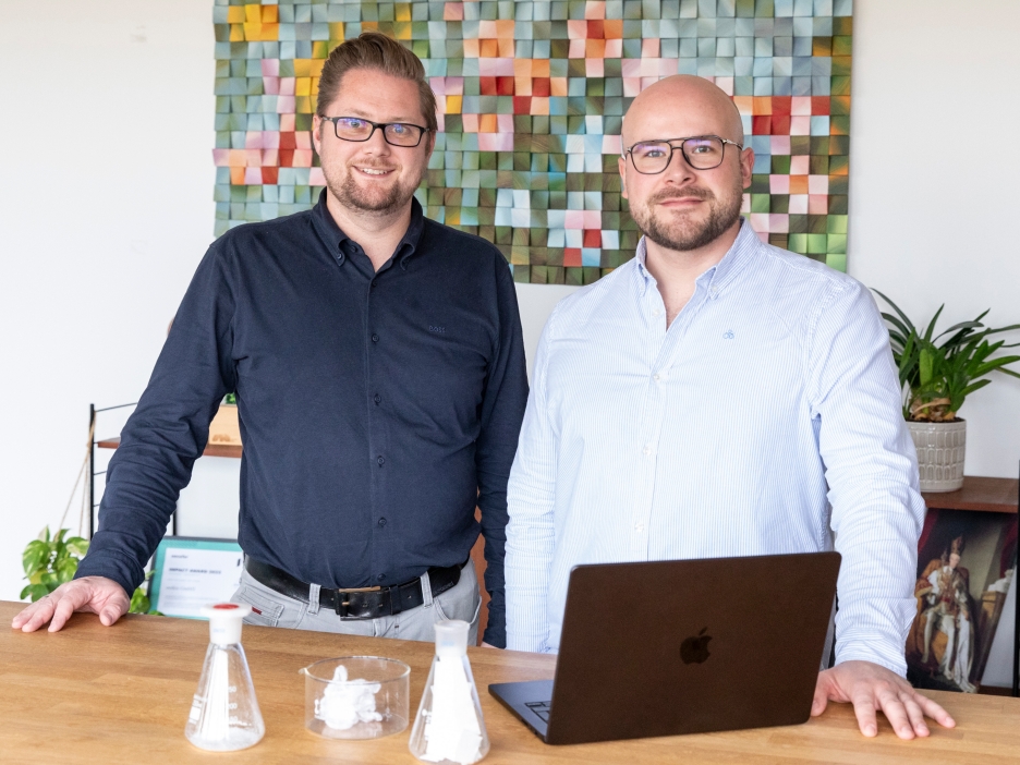 Dr. Tobias Börnhorst (l., CTO) und Steffen Gerlach (CEO) sind Gründer des Start-ups eeden und stehen vor einem bunten Bild an einem Schreibtisch
