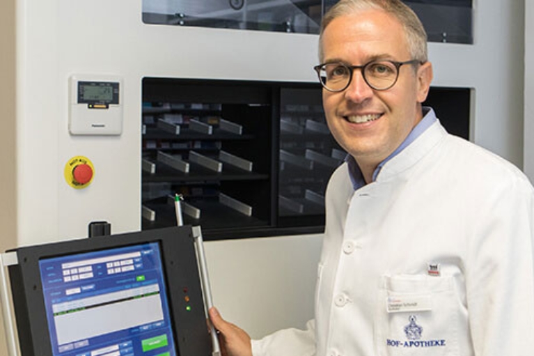 Apotheker Christian Schmidt vor seiner automatischen Rollschrankanlage mit integriertem Laptop