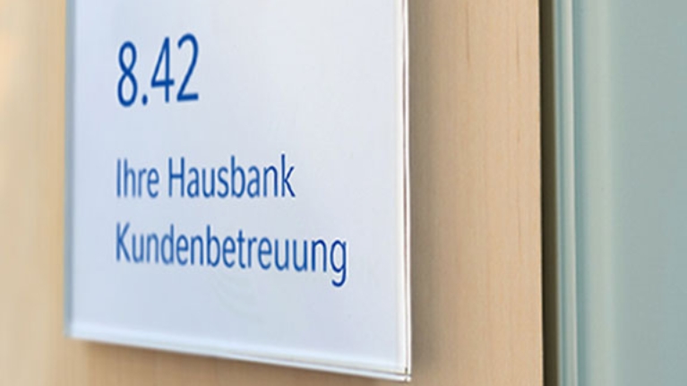 Büro-Türschild mit der Aufschrift: Ihre Hausbank Kundenbetreuung
