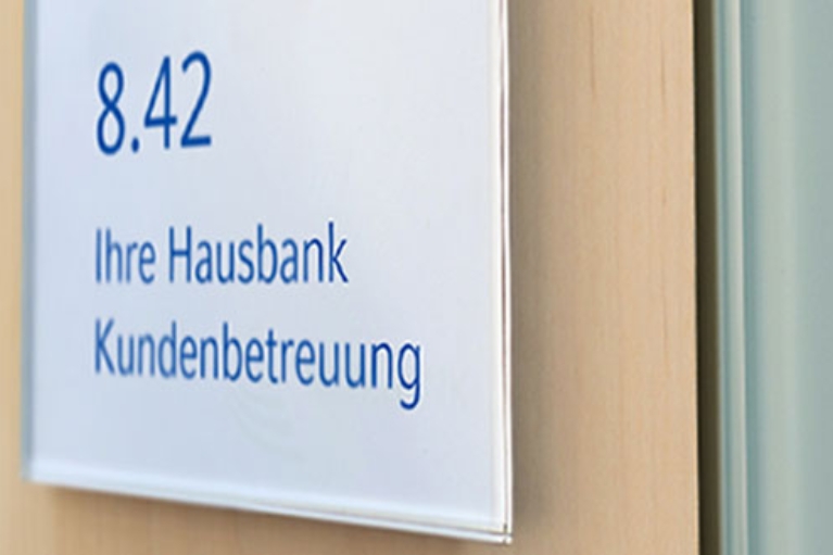 Büro-Türschild mit der Aufschrift: Ihre Hausbank Kundenbetreuung