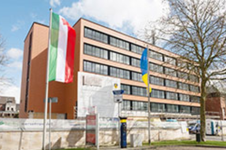 Ein kommunales Gebäude, an dem Baumaßnahmen durchgeführt werden, mit der NRW-Fahne im Vordergrund