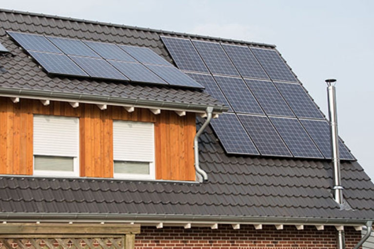 Saniertes Hausdach mit einer Solaranlage.