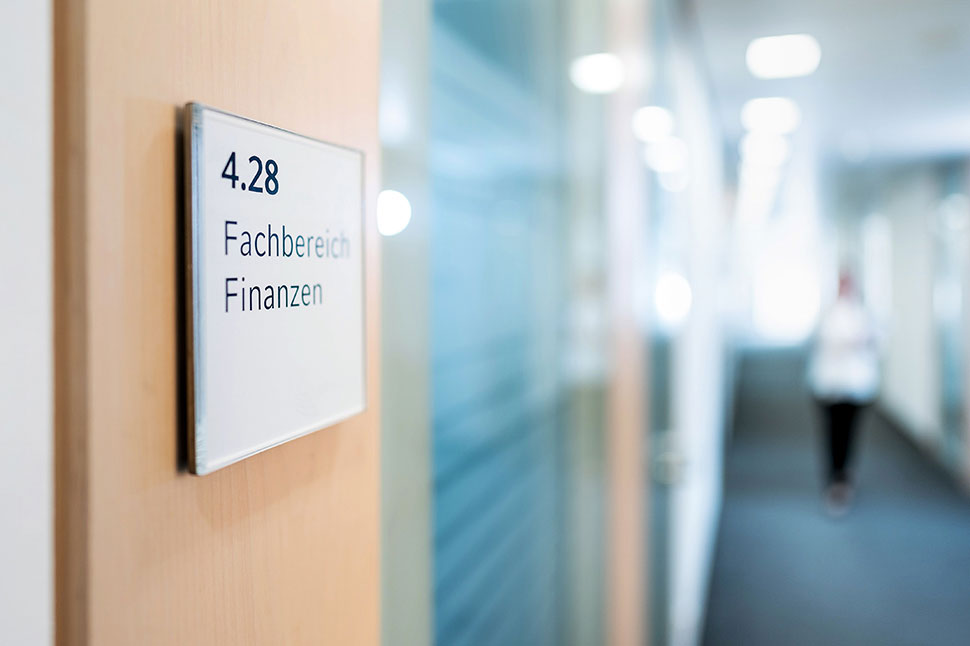 Das Bild zeigt eine Tür mit dem Schild Fachbereich Finanzen in einem Rathaus.