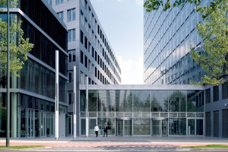 Der Eingangsbereich der NRW.BANK-Zentrale in Düsseldorf von außen, mit großer Fensterfront und Drehtüren