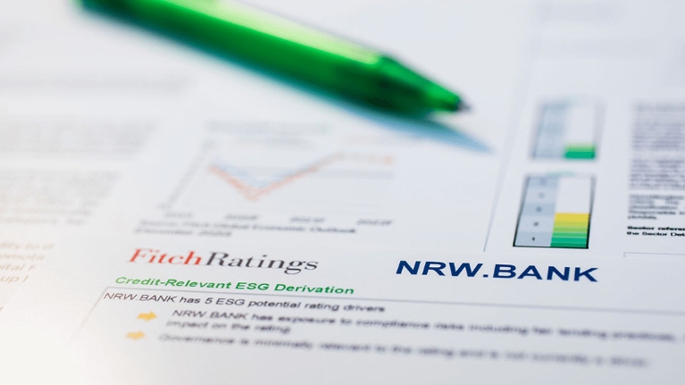 Ein ausgedruckter Ratingbericht der NRW.BANK, auf dem ein Kugelschreiber liegt