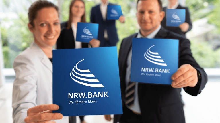 Fünf Mitarbeiterinnen und Mitarbeiter der NRW.BANK heißen neue Kolleginnen und Kollegen herzlich willkommen.