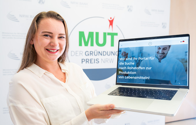 Marina Billinger von Leroma vor dem MUT - DER GRÜNDUNGSPREIS NRW-Logo