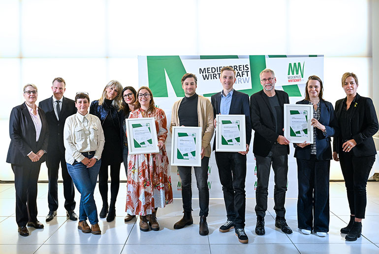 Die Preisträgerinnen und Preisträger des MEDIENPREIS WIRTSCHAFT NRW 2024 Helga Szentpéteri, Ursula Welter, Nina Voigt, Annabell Brockhues, Till Eckert, Tobias Fenneker, Claus Hanischdörfer und Tatjana Mischke (von links) mit Gabriela Pantring (links vorne), stellvertretende Vorsitzende des Vorstands der NRW.BANK, Edzard Bennmann (links hinten), Leiter Unternehmenskommunikation der SIGNAL IDUNA Gruppe, und Wirtschafts- und Klimaschutzministerin Mona Neubaur (rechts)