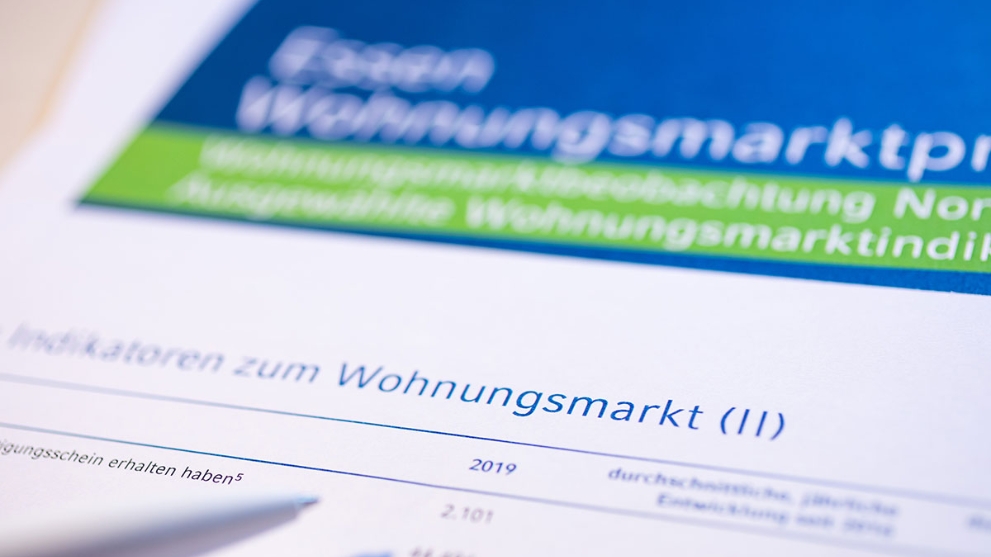 Ein Kugelschreiber zeigt auf eine Tabelle in Wohnungsmarktprofil