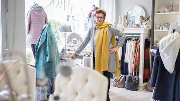 Petra Hustadt in Ihrem Geschäft Herzstück, umgeben von Kleidung und Wohnaccessoires