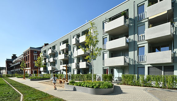 Hausfassade des neuen Clouth Quartiers mit Balkonen und einem Spielplatz