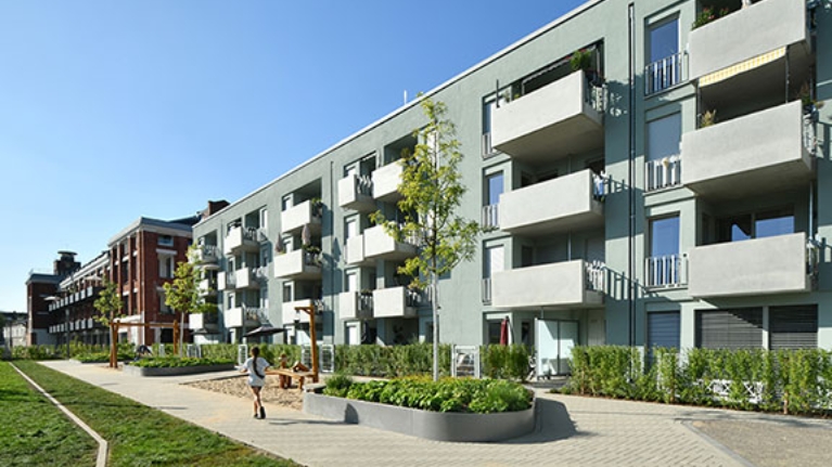 Hausfassade des neuen Clouth Quartiers mit Balkonen und einem Spielplatz