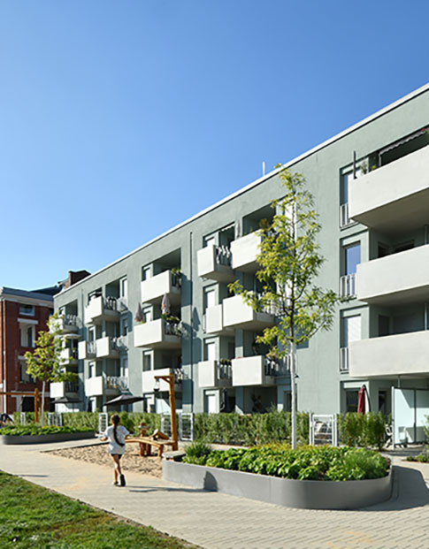 Hausfassade des neuen Clouth Quartiers mit Balkonen und einem Spielplatz