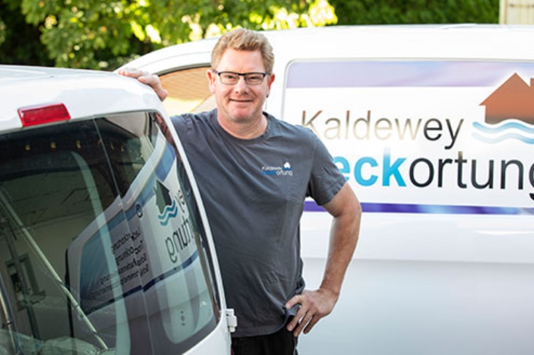 Christian Kaldewey steht vor einem weißen Transporter mit der Aufschrift "Kaldewey Leckortung"