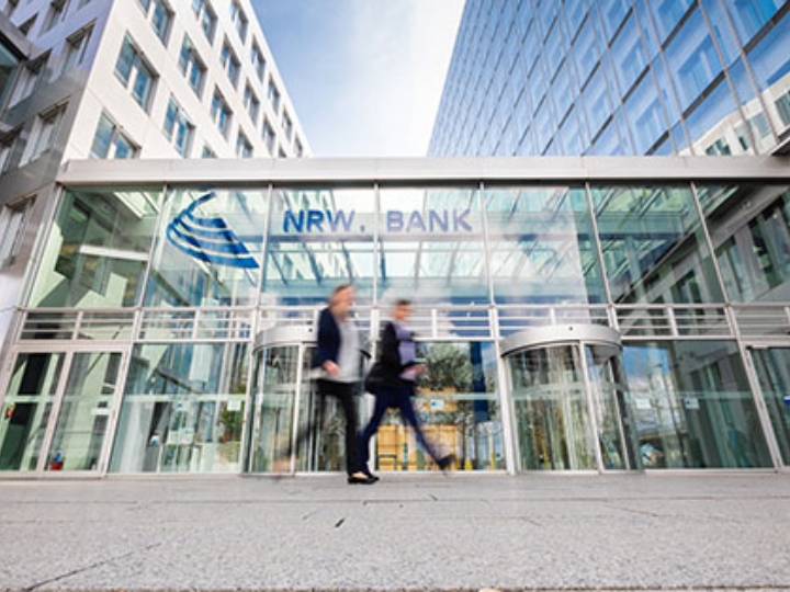 Zwei Menschen vor dem gläsernen Eingangsbereich der NRW.BANK-Zentrale in Düsseldorf