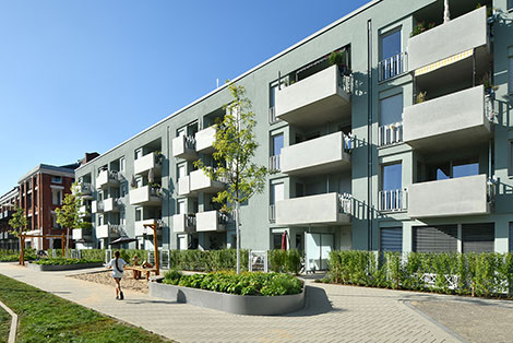 Hausfassade des neuen Clouth Quartiers mit Balkonen und einem Spielplatz