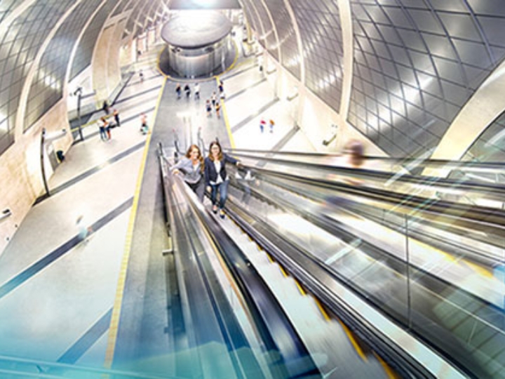 Zwei Frauen fahren auf einer modernen Rolltreppe nach oben.