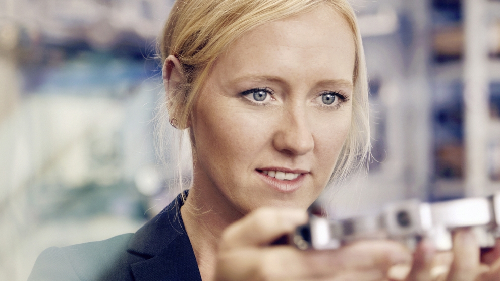 Unternehmerin Melanie Baum betrachtet ein produziertes Bauteil.