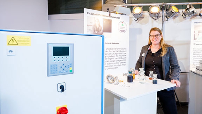 Gründerin Christine Batsch vor einer Destillationsanlage