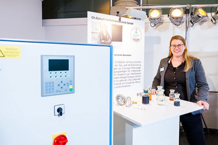 Gründerin Christine Batsch vor einer Destillationsanlage