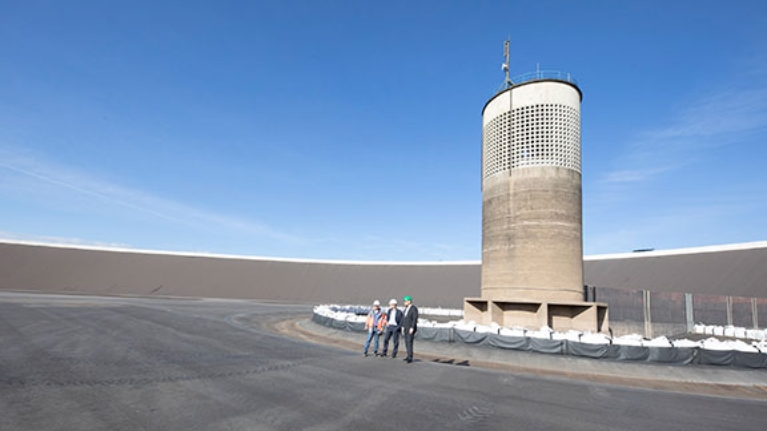 Drei Männer stehen im Außenbereich des Pumpspeicherwerks Rönkhausen.