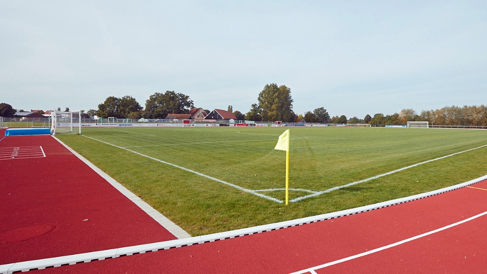 Fußballplatz mit roter Laufbahn außen herum